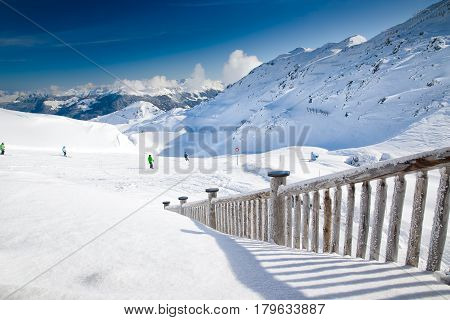 People Skiing On The Prepared Slope With Fresh New Powder Snow In Alps