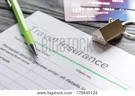 Traveling concept with insurance application form and credit cards on gray wooden table background