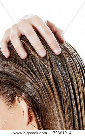 Photo of woman applying hair conditioner.