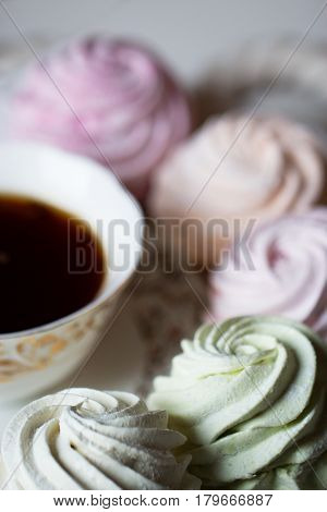 Sweet homemade dessert - marshmallow (zephyr) with cup of tea.Homemade marshmallows on a light background. Russian currant and mango zephyr.