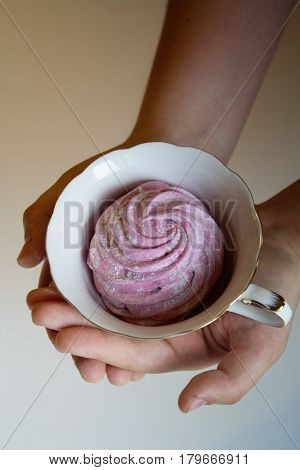Marshmallow (zephyr) in woman's hand. zephyr in hands