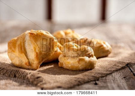 Pies in peasant style on a wooden rustic table. Morning light. Selective focus.