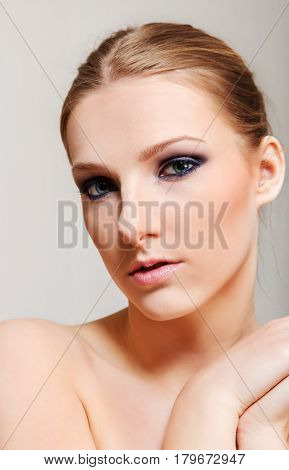 Attractive blonde topless woman with dark eye make up
