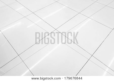 Flooring tile background and reflection of luminaire.