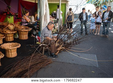 CAMACHA MADEIRA PORTUGAL - SEPTEMBER 10 2016: A basket weaver at work in the factory shop in Camacha Madeira Portugal