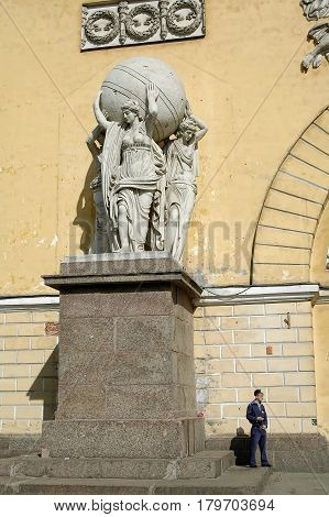 Saint-Petersburg, Russia - May 14, 2006: Sentry stands near Statues of nymphs carrying the globe on the facade of the Main Admiralty