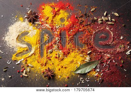 Word Spice drawing on various spices on stone table. Top view