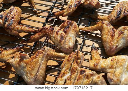 Close up of Cooking delicious Shish kebab on the grill of chicken wings. Chicken wings at outdoors grill. Summer Weekend and party concept.