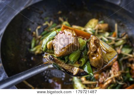 Traditional stir fried Chicken Gung Bao with Vegetable as close-up on Shovel