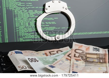 Handcuffs On The Laptop And Money On The Keyboard. Cyber Hacker Crime Concept.