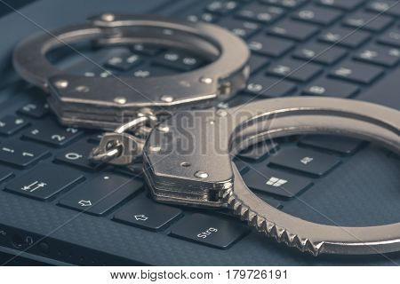 Handcuffs On The Laptop Close-up. Cyber Hacker Crime Concept.