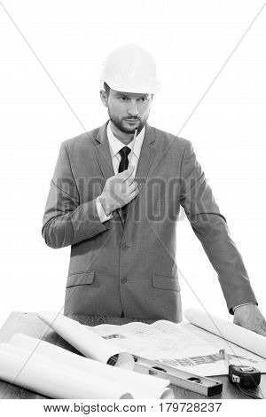 Thinking hard. Monochrome shot of a handsome bearded mature male businessman engineer in a hardhat looking away thinking while drawing up a building plan professionalism occupation career concept