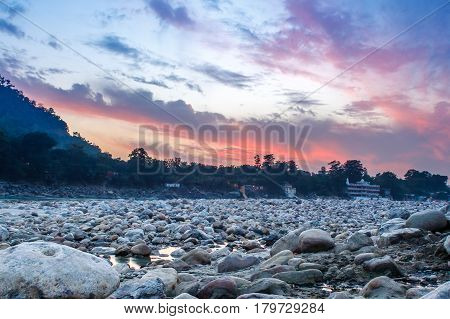 View of River Ganga and lots of stones after sunset with amazing dramatic sky. Rishikesh. India.