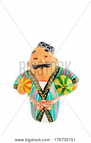 Ceramic statuette of Uzbek man wearing in traditional costume with watermelon and honeymelon isolated with work path.