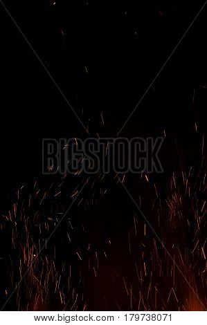 Photo of hot sparking live-coals burning, spark of bonfire.