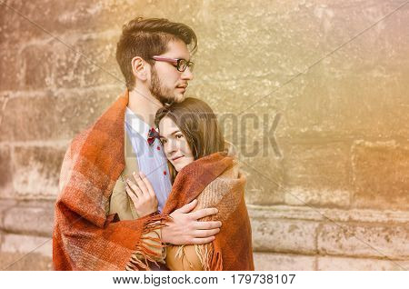 Young Fashion Elegant Stylish Couple Standing, Embracing, Wrarps In Pled On Streets Of Old European 