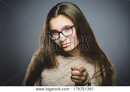 Closeup Thoughtful or contemptuous girl show at camera isolated on Gray.