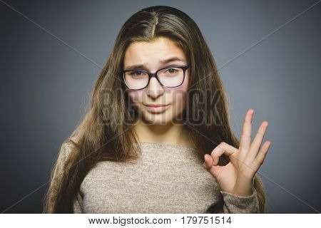 Closeup Portrait of handsome teen show Ok isolate on grey background.
