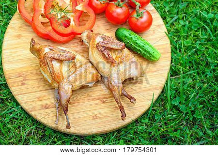 Delicious Fried Quail With Fresh Juicy Vegetables On The Wooden Round Board On Green Grass. Prepared