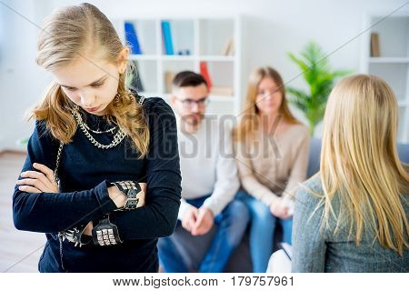 Teenage girl during therapy session while therapist is taking notes