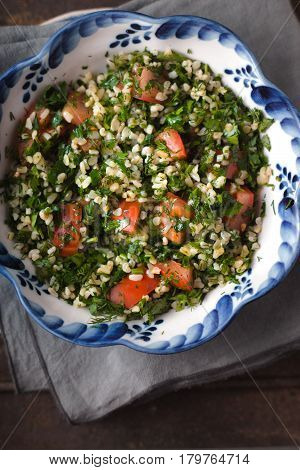 Tabouli salad in the ceramic bowl top view
