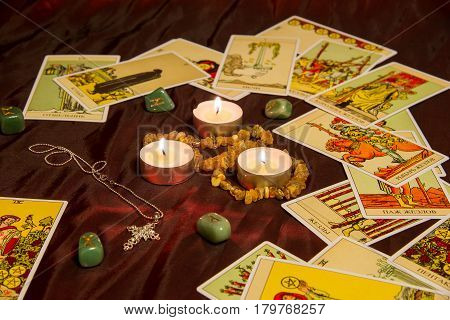 Moscow Russia - December 4 2016: Rider-Waite tarot cards with runes and burning candle. Esoteric background.