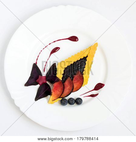 Gourmet food. Gentle dessert with black plums blueberries cream biscuit pie jelly and edible petals. Easy food for ladies. Square image
