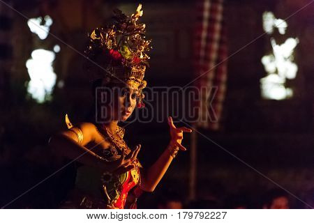 Ubud, Indonesia - August 8, 2016: Beautiful balinese woman dances during a traditional Kecak Fire Dance ceremony in Hindu temple.