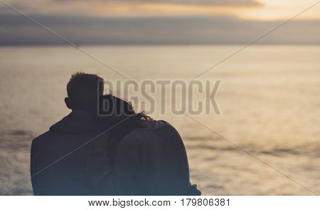 Couple hugging on the beach on background ocean sunrise silhouette two romantic people cuddling and looking on rear view evening seascape hipster enjoy sunset together travel holidays vacation
