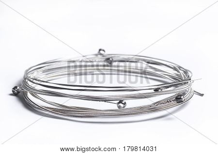 Rolled strings for musical instruments on white background