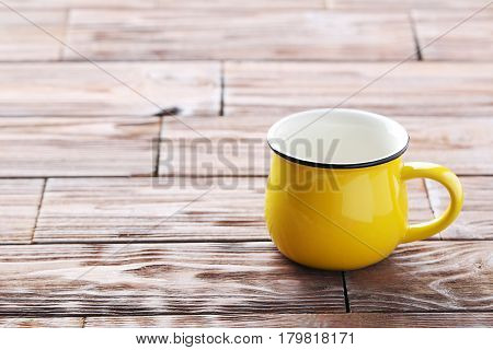 Yellow mug on the brown wooden table