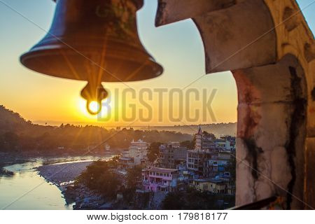View from the temple under huge bell on River Ganga and Lakshman Jhula bridge at sunset. Rishikesh. India