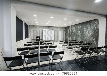 Modern university group study room with white desk and chairs.