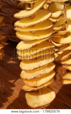 Fried Sliced Potatoes Stuck In The Wooden Skewer Into The Street