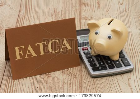 Complying with the US Foreign Account Tax Compliance Act A piggy bank on a calculator with text FATCA