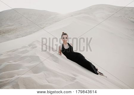Woman in a black dress in desert