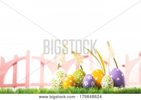 Bunch of easter eggs in pastel colors on grass, isolated on white background