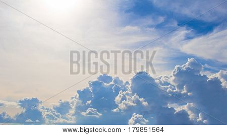 Cloudy sky with sunny flare. Rainy clouds banner. Natural photo scene with cloud cumulus above horizon. Skyscape in afternoon. Tropical rain season weather. Blue and white cloudiness banner template
