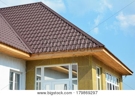 Roofing Construction. House wall repair renovation insulation detail. Building insulation exterior added to buildings for comfort and energy efficiency. Rain Gutter. Soffit and Fascia installation.
