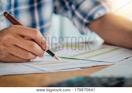 hand hold fountain pen pointing stock maket chart in office. vintage effect.