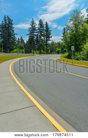 Road curve with 15km/h speed limit leading to the forest