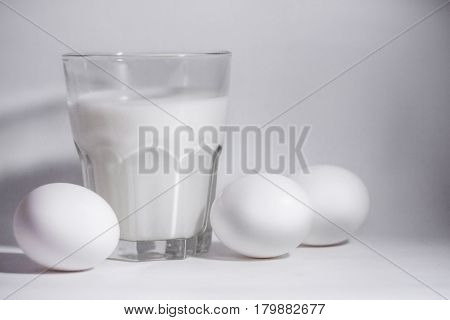 A glass of milk on a white background eggs