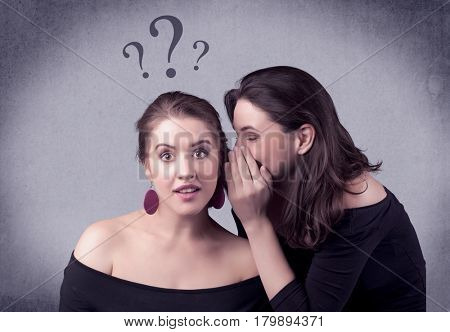 A teenager girl looking confused with drawn question marks above the head, while a girlfriend whispers something in her ear concept.