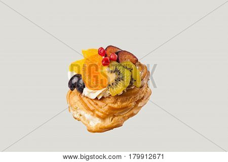 Closeup of cake with fresh fruits isolated on gray background.