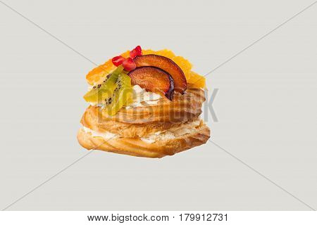 Closeup of cake with fresh fruits isolated on gray background.