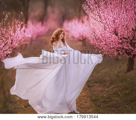 Beautiful girl in a pink dress in peach garden