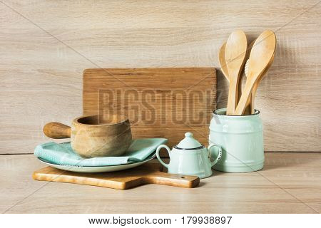 Wooden rustic and vintage crockery tableware utensils and stuff on wooden table-top. Kitchen still life as background for design. Image with copy space.