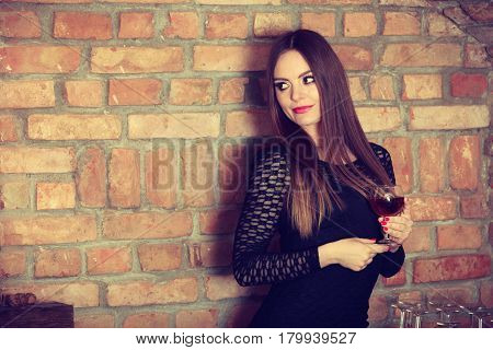 Woman Tasting Wine In Rural Cottage Interior