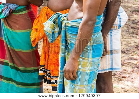 Closeup of Vedda men standing in group in waistcloths