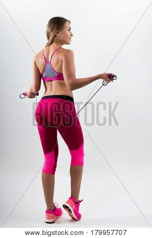 Woman In Sportswear Holding A Rope In His Hands. White Background. Studio.